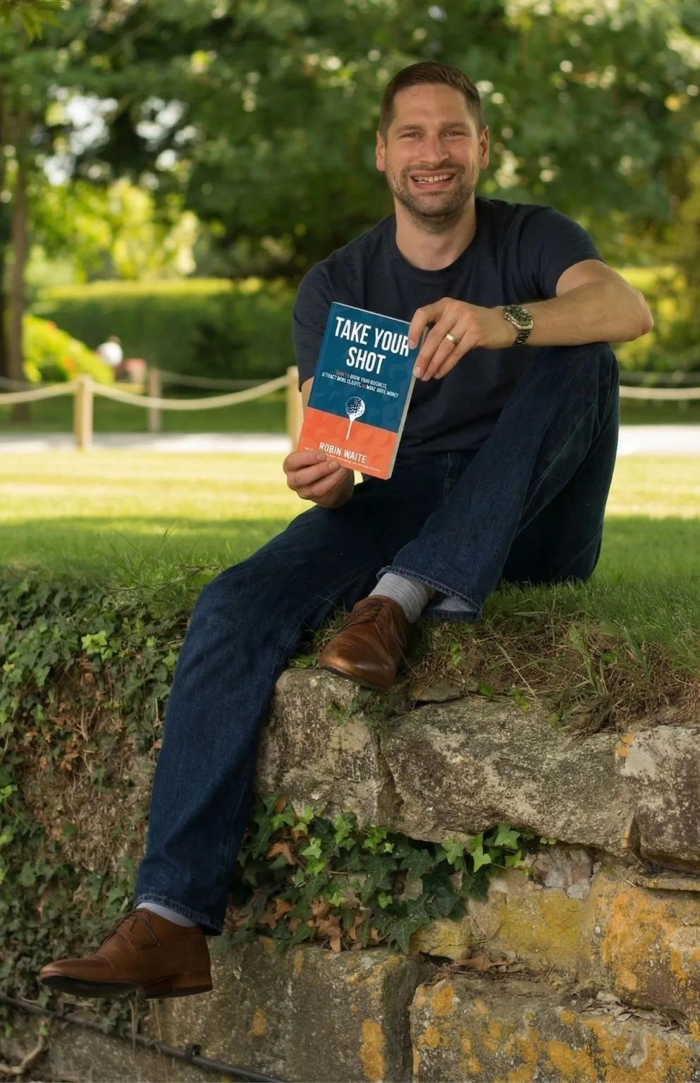 Robin Waite Holding a Copy of Take Your Shot