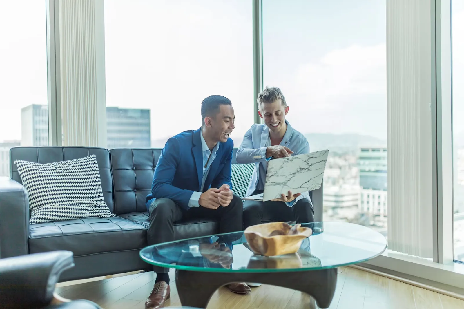 Two men wearing suits with a laptop 