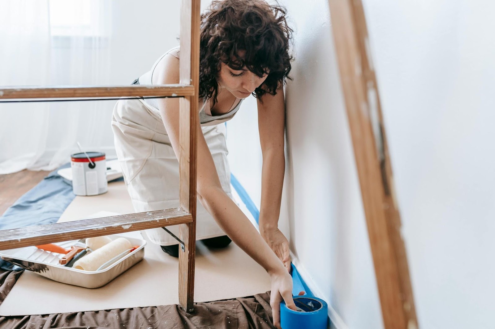 A woman painting her bedroom wall