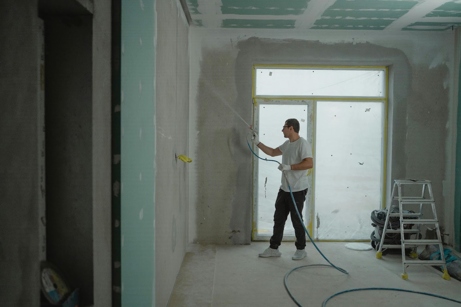 Man in white shirt holding spray hose