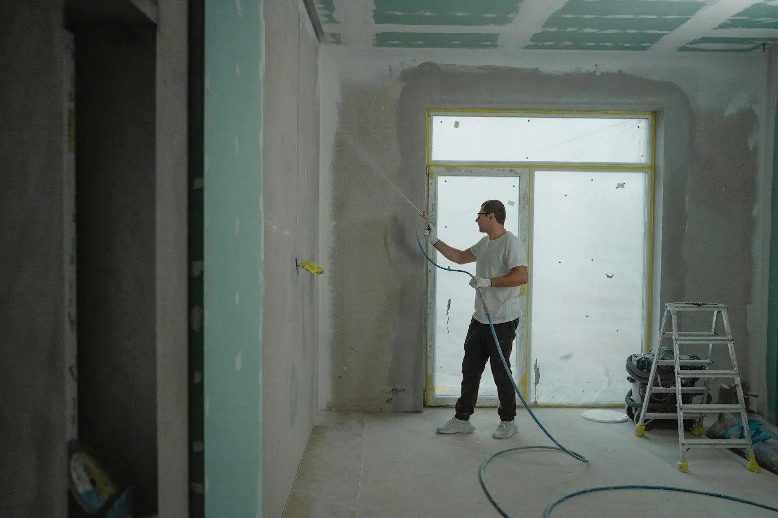Man in white shirt holding spray hose