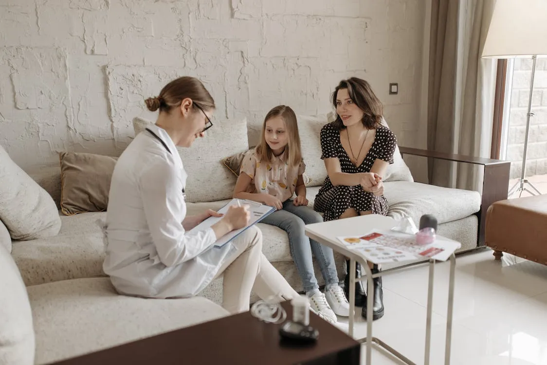 A doctor in consultation with mother and her daughter