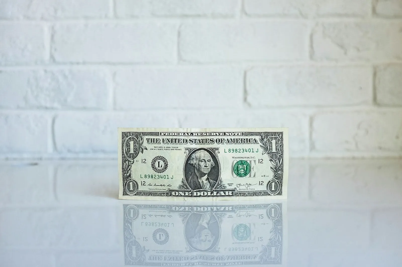 A dollar bill on a white table