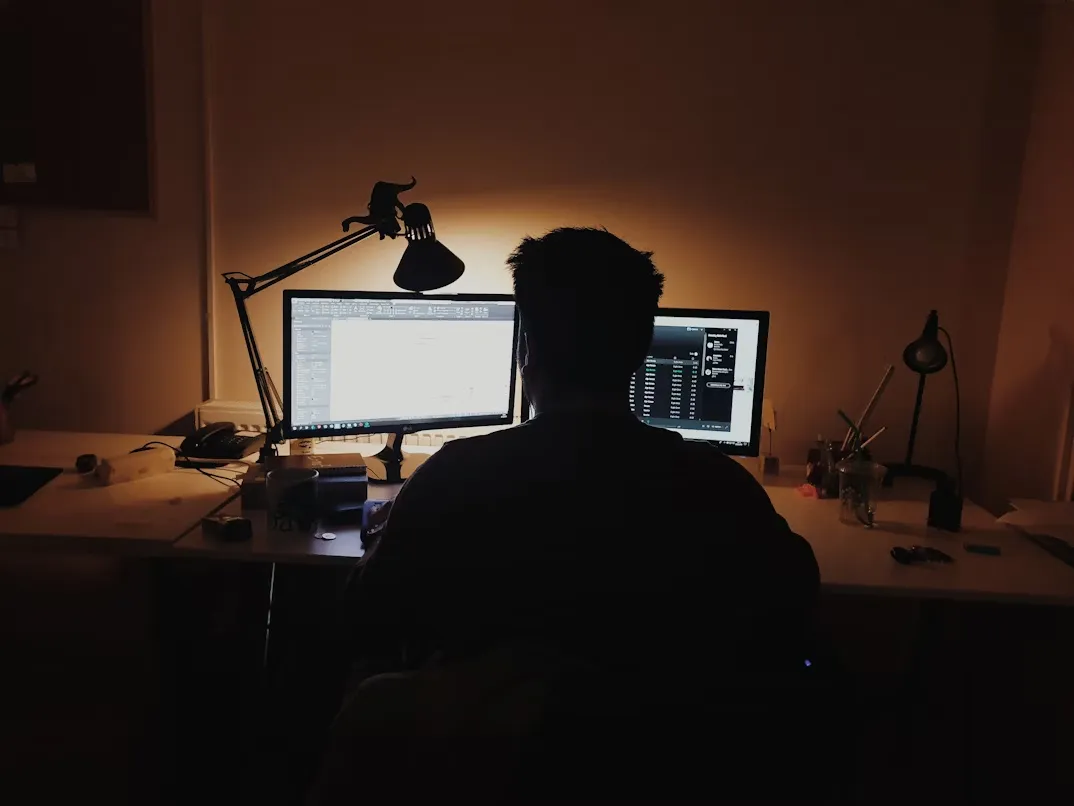 Person sat using computers at night