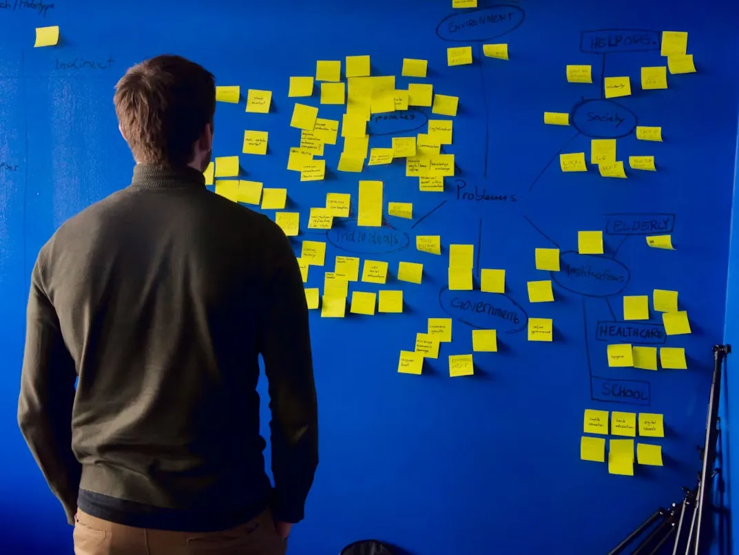Male entrepreneur looking at a wall of post it notes