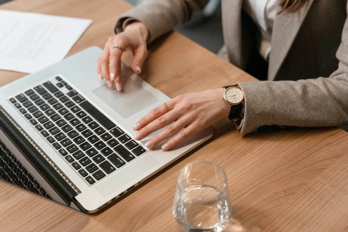 Person using a laptop on wooden table