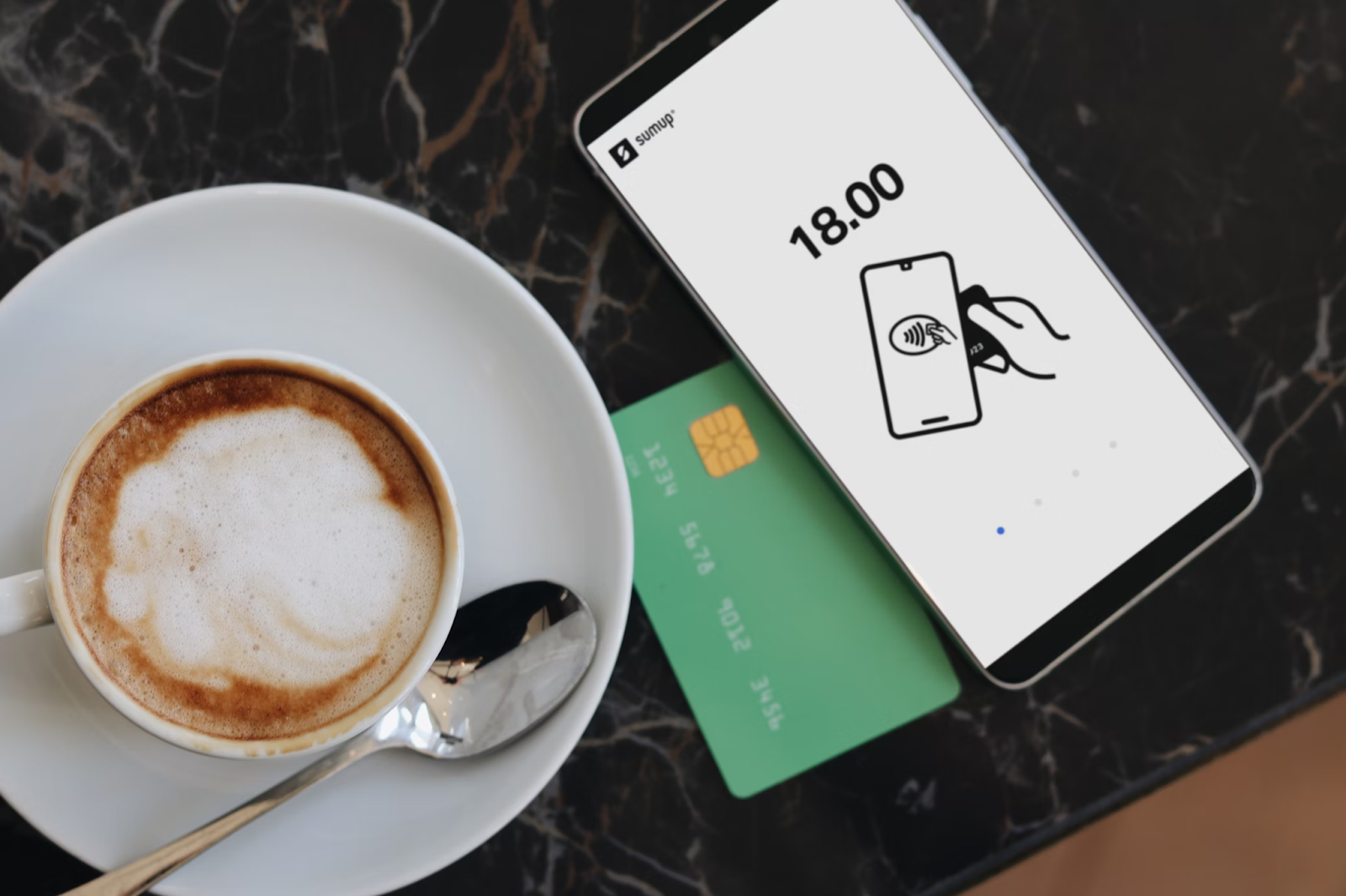 A cup of coffee next to a credit card