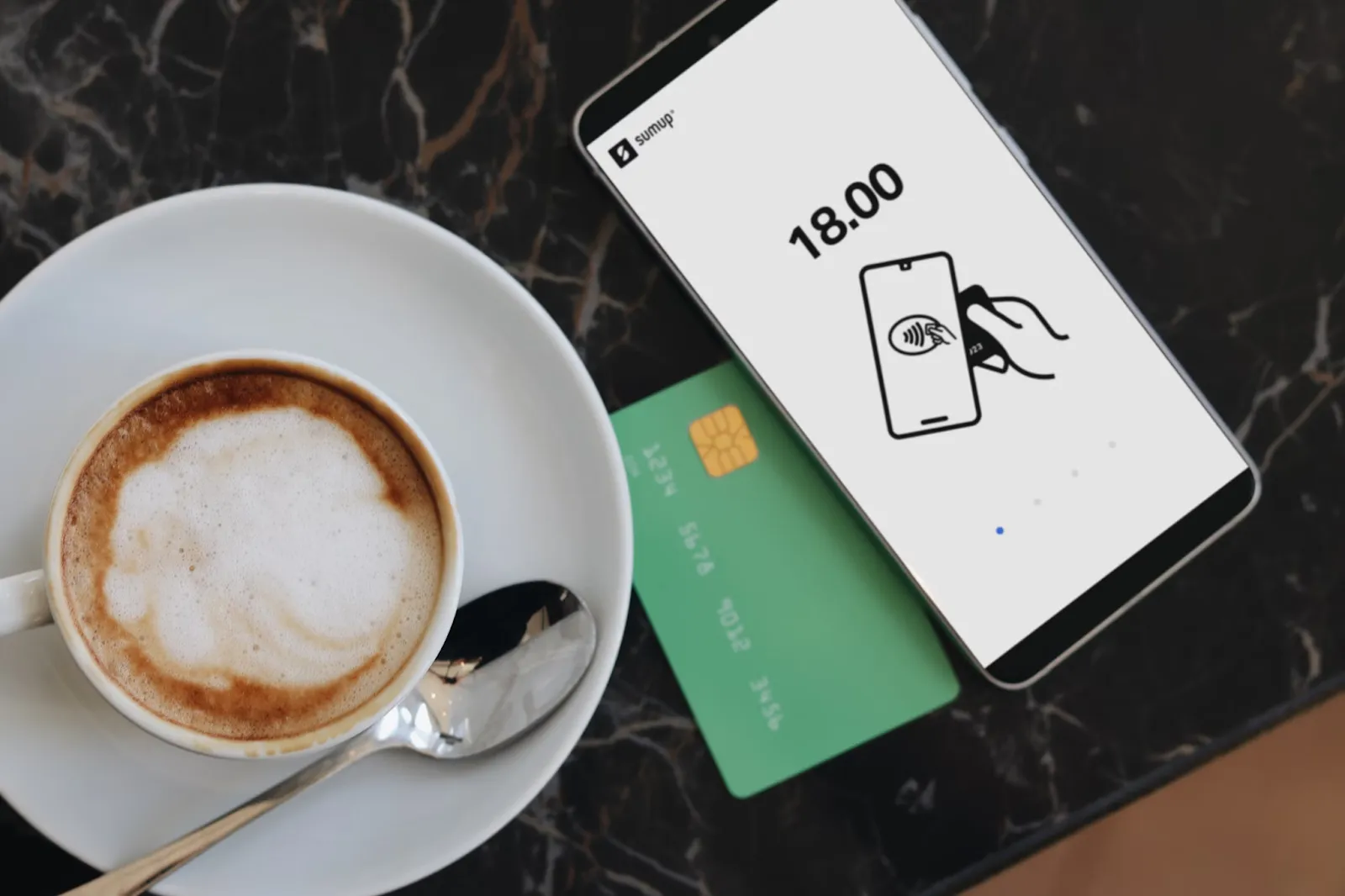A cup of coffee next to a credit card