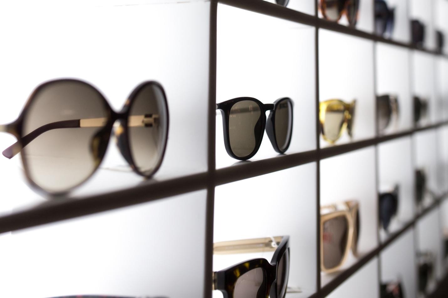 Rows of sunglasses on display shelf