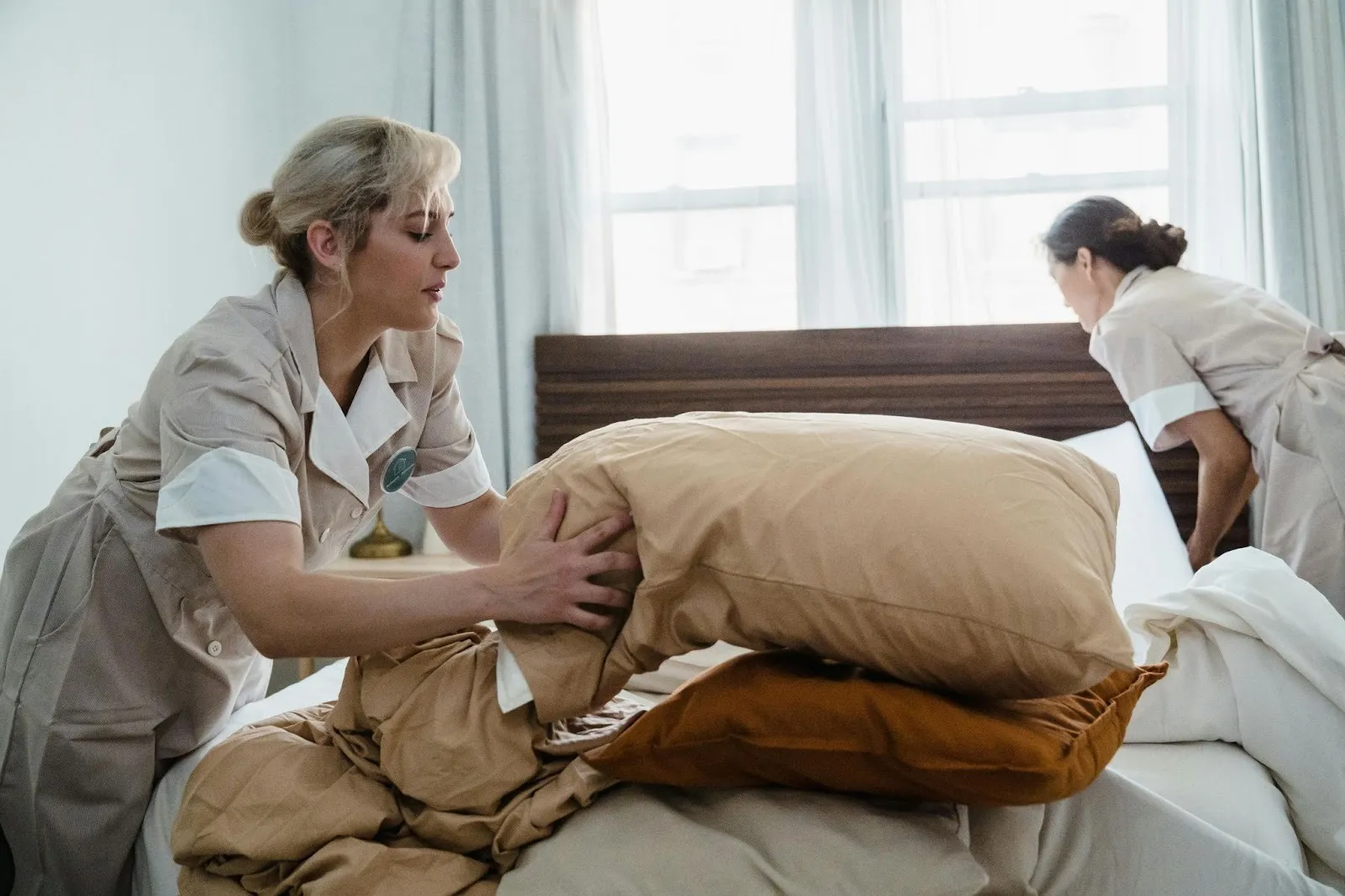Two women making a bed
