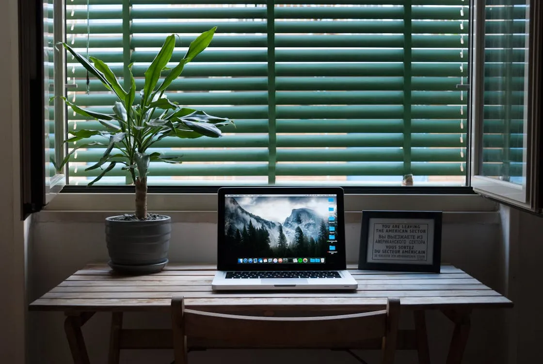 Laptop on home desk by a window