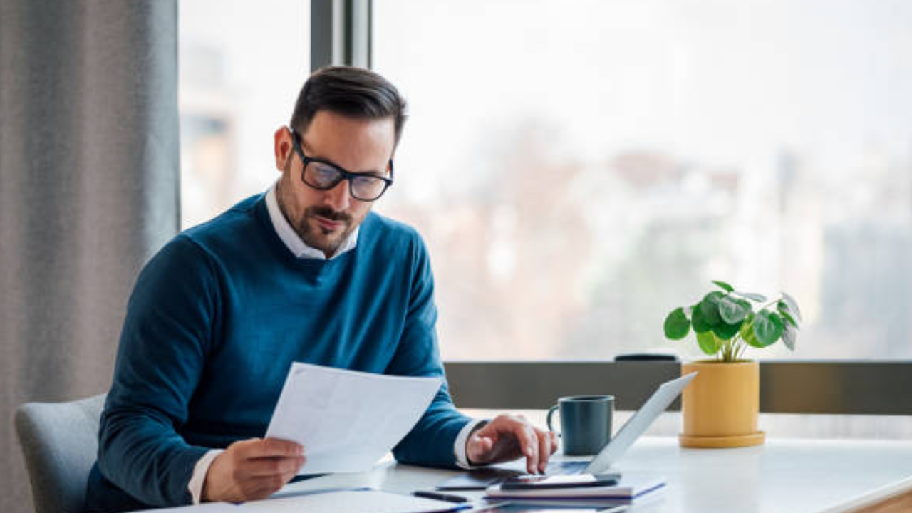 A man sat on a laptop reading a document