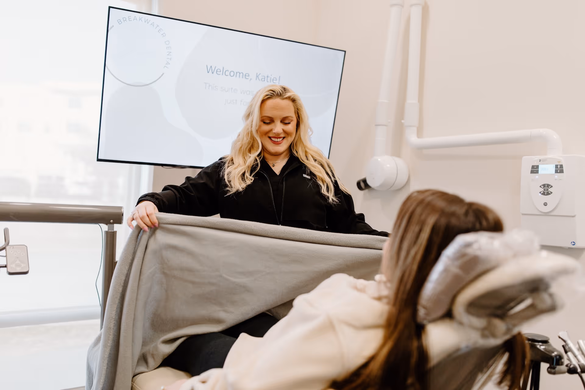A woman sitting in a chair holding a blanket.