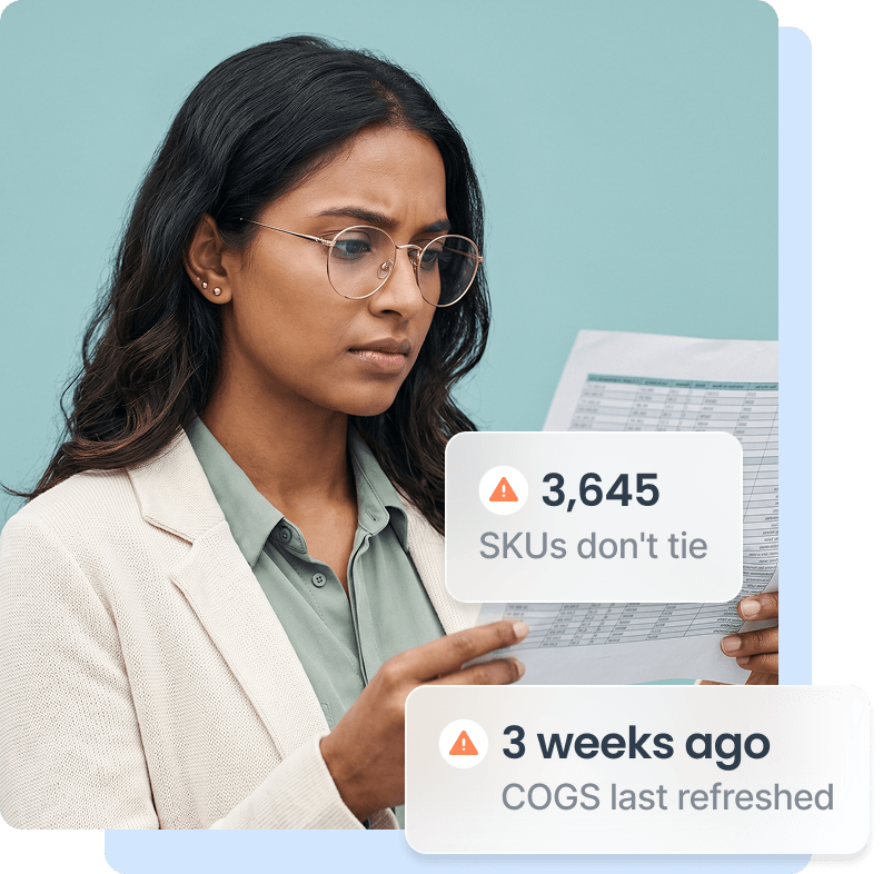 Woman with glasses in a beige blazer looks concernedly at a printed spreadsheet.