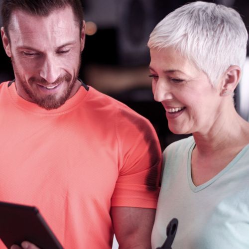 Eine Frau schaut sich ihre Bio Age Ergebnisse mit ihrem Trainer an.