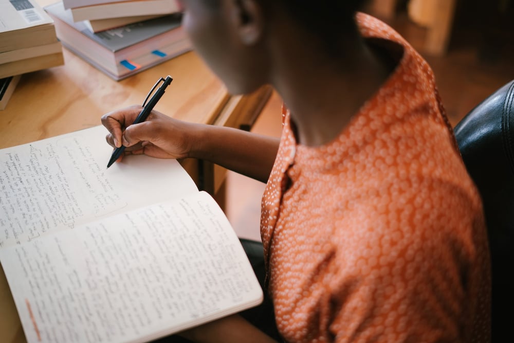 A person writes in a notebook.