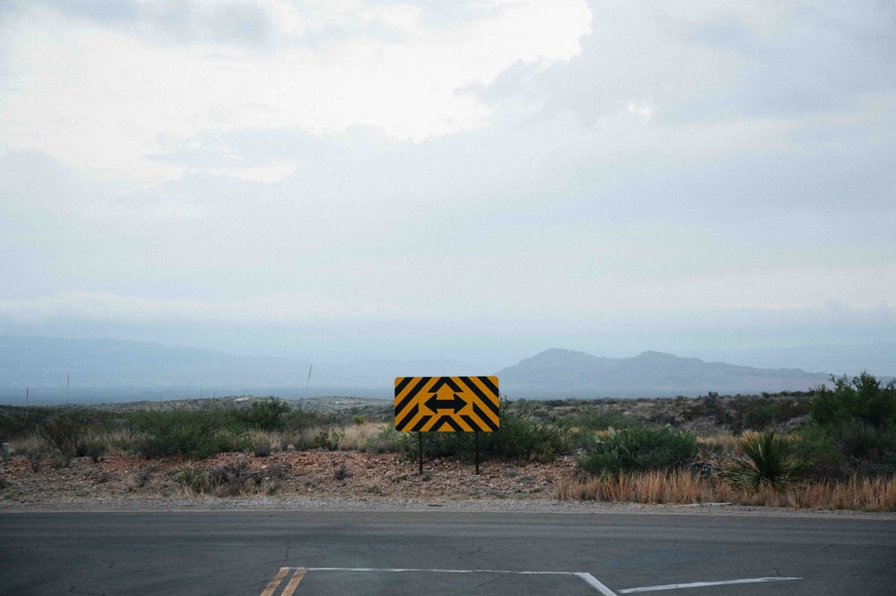 The dead end of a country road with a sign pointing left and right.