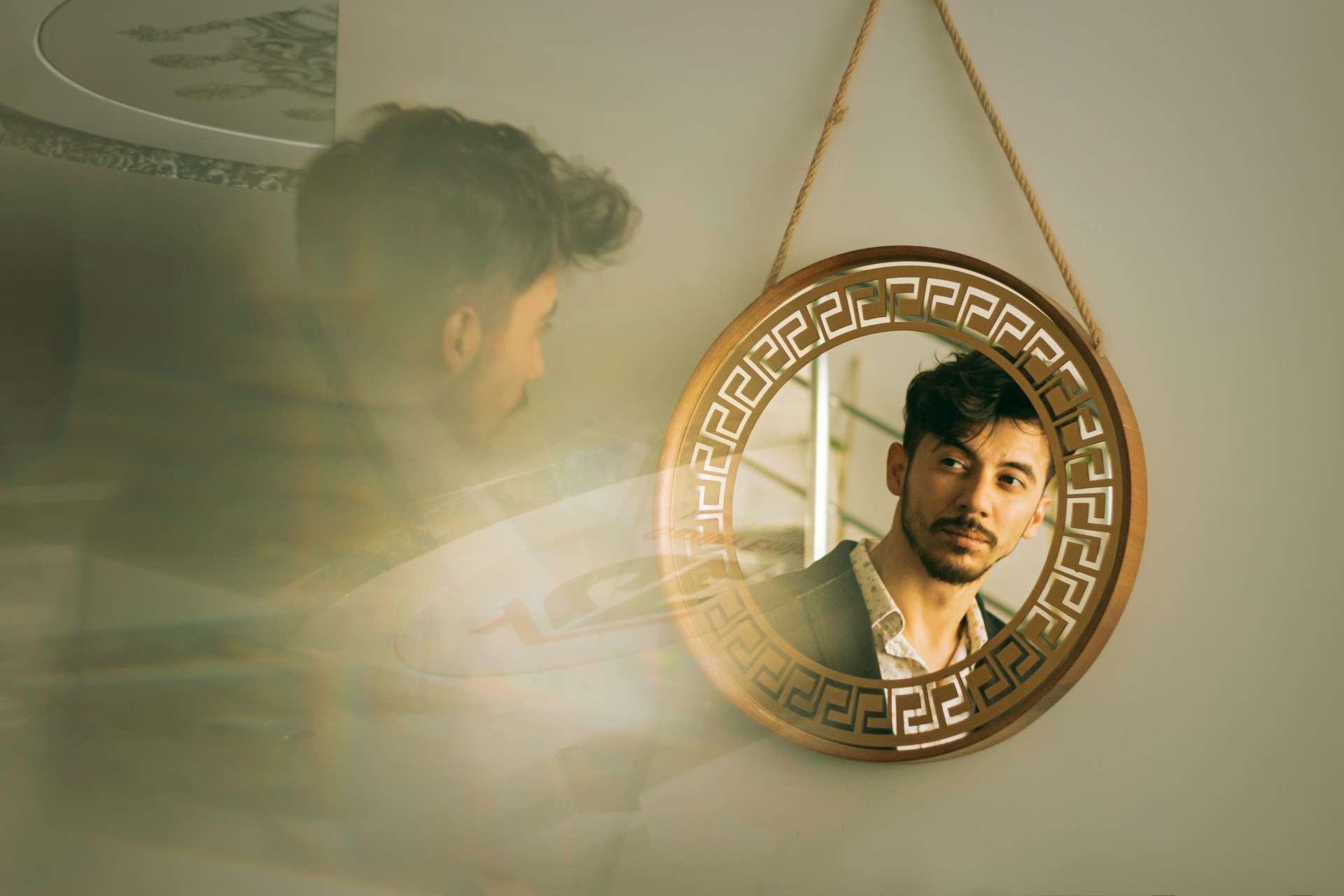 A person looks at their reflection in a round mirror.