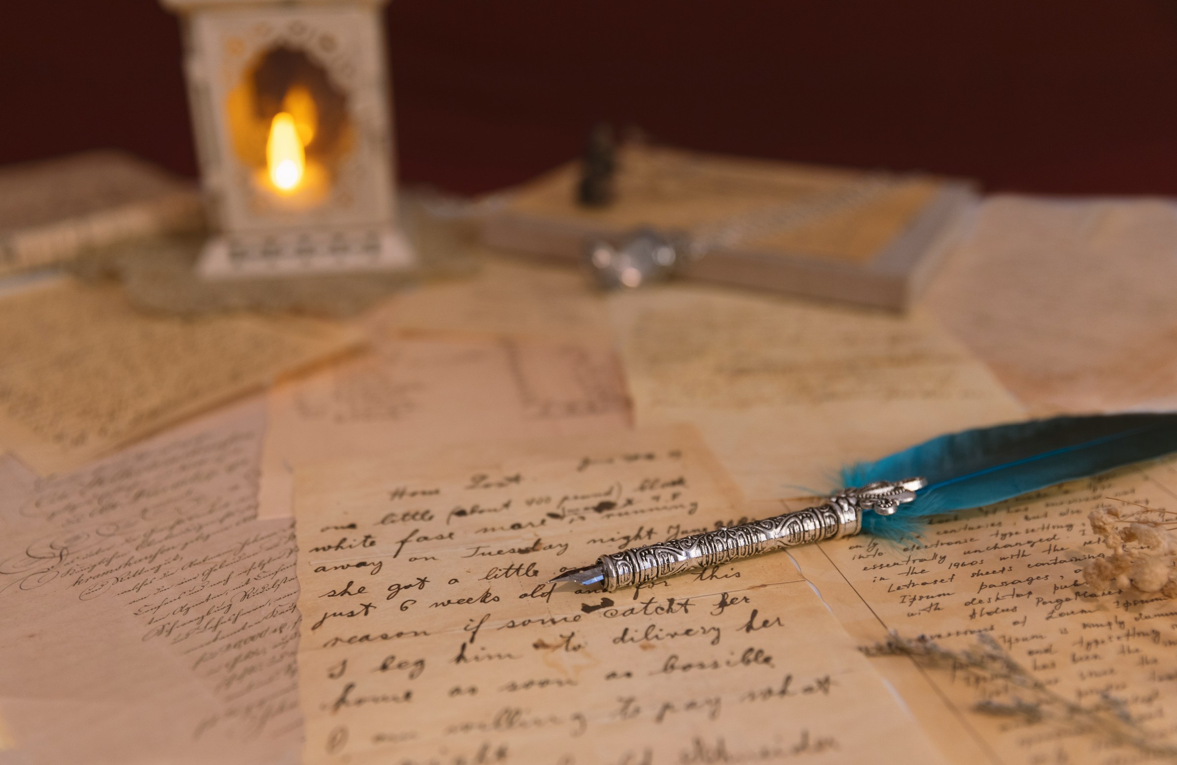 A quill rests on handwritten poems.