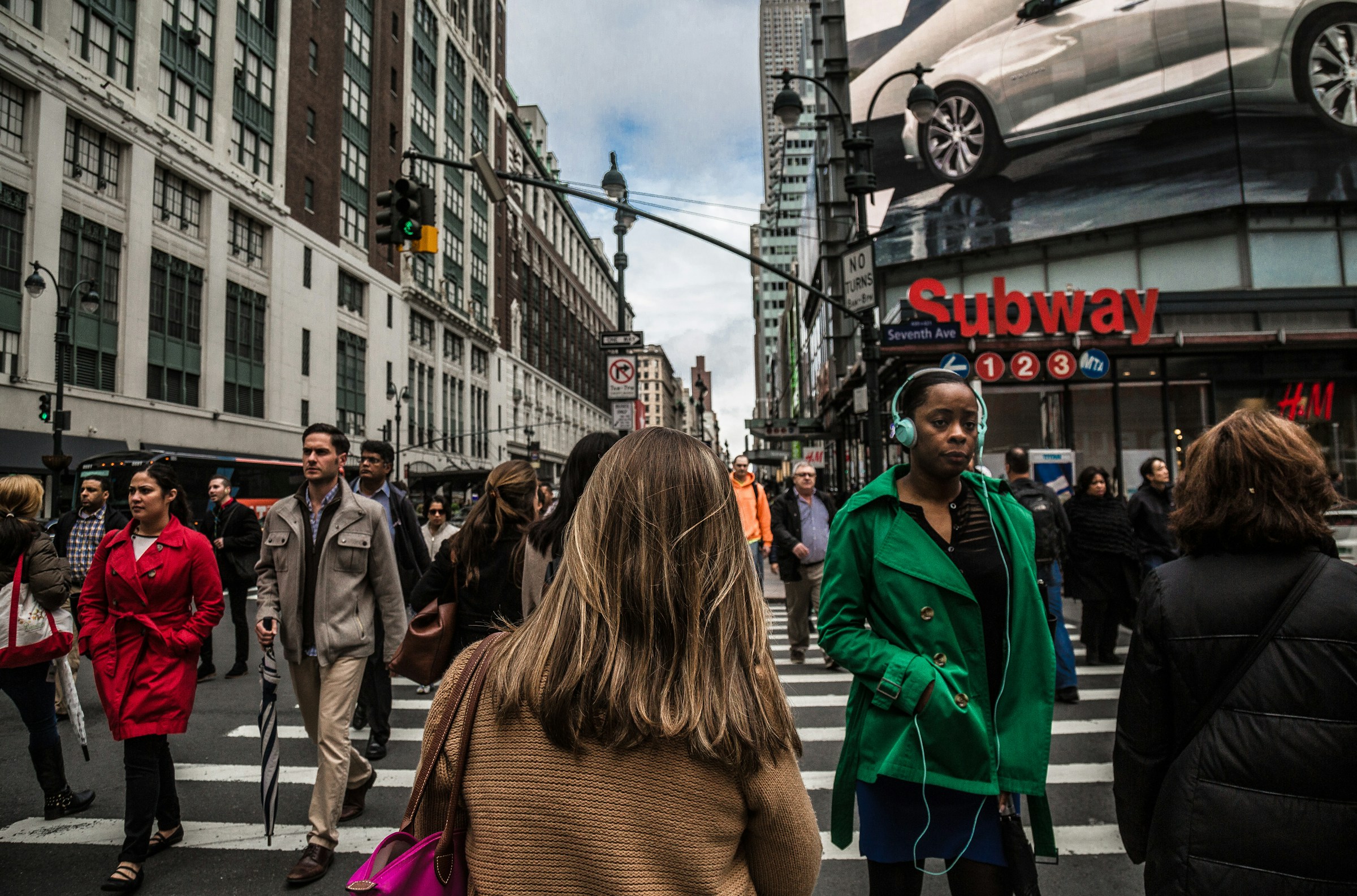 Crowds of people walking in opposite directions on a city crosswalk.