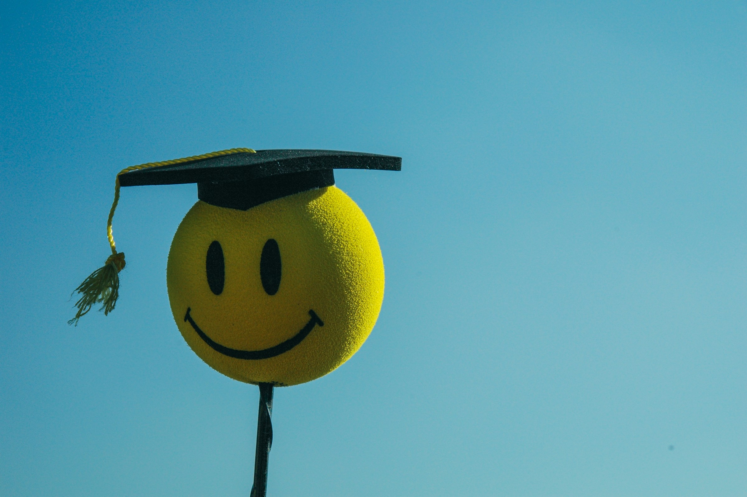 A smiley face antenna ball wearing a mortar board.
