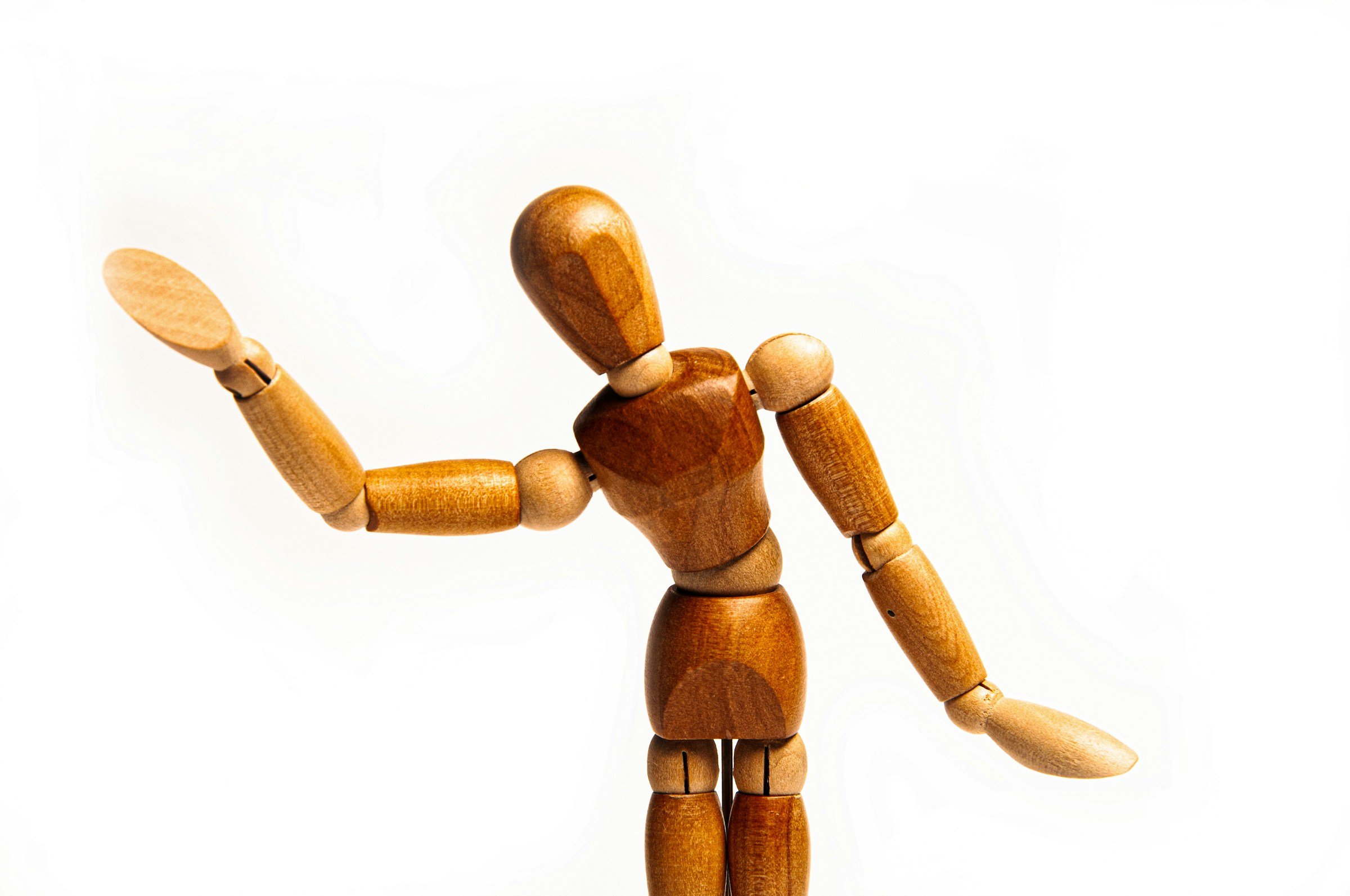 A wooden artist's figure seems to wave at the viewer.