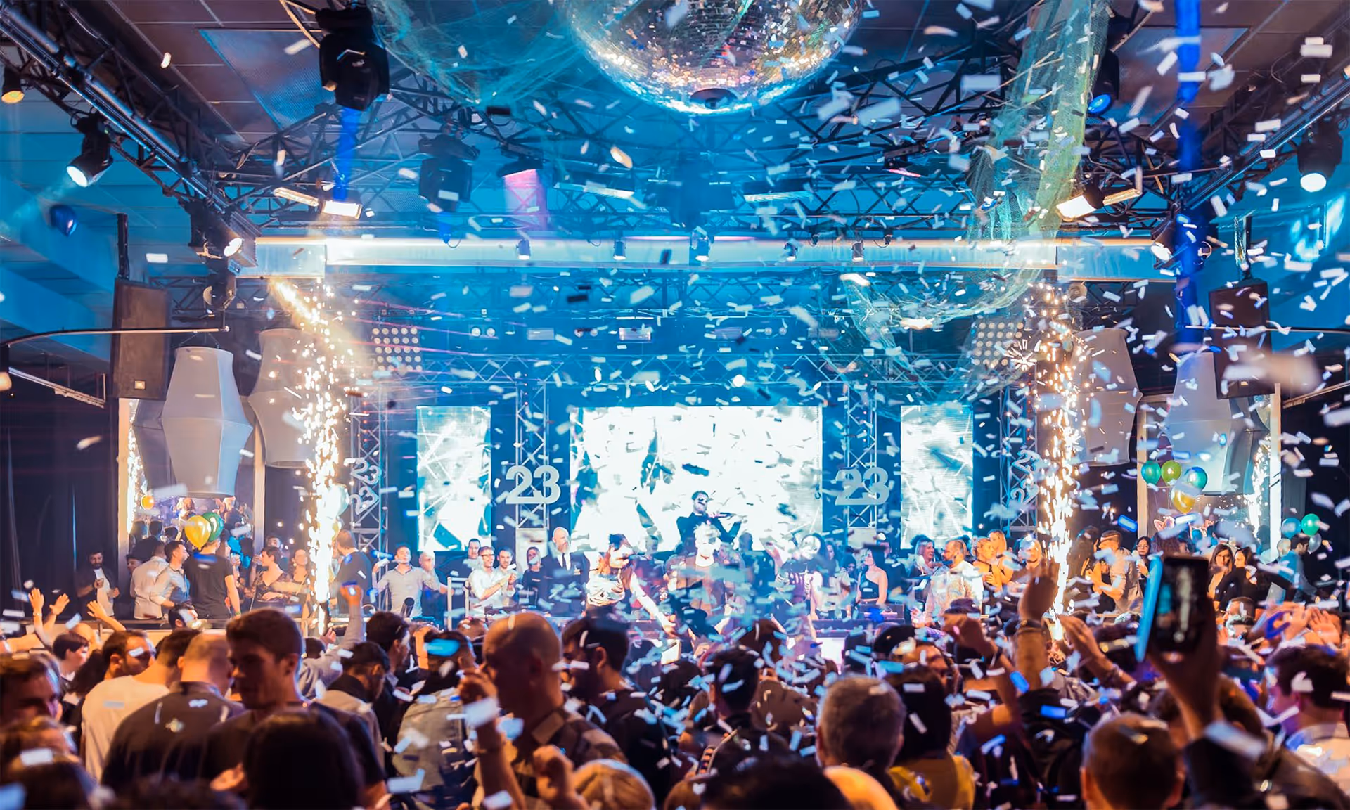 Feiernde Menge vor einer Bühne mit Konfetti