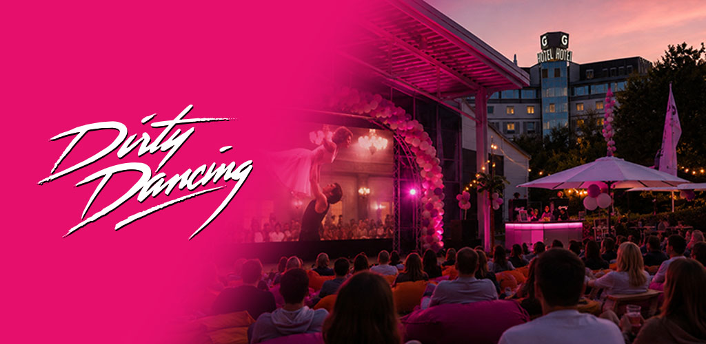 Menschen sehen abends einen Outdoor-Film mit Tanzeinlage vor einem Hotel.