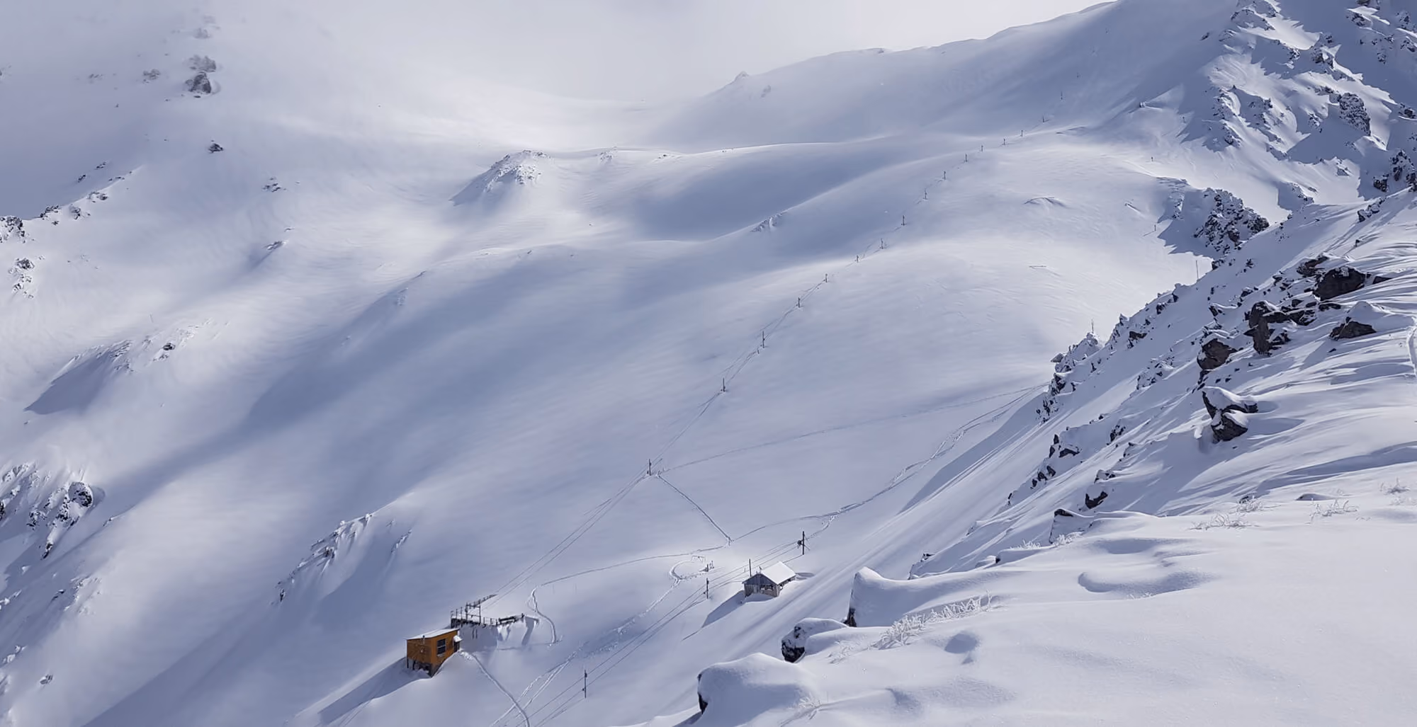 View looking down on the Craigieburn ski field showing towline in fresh snow.