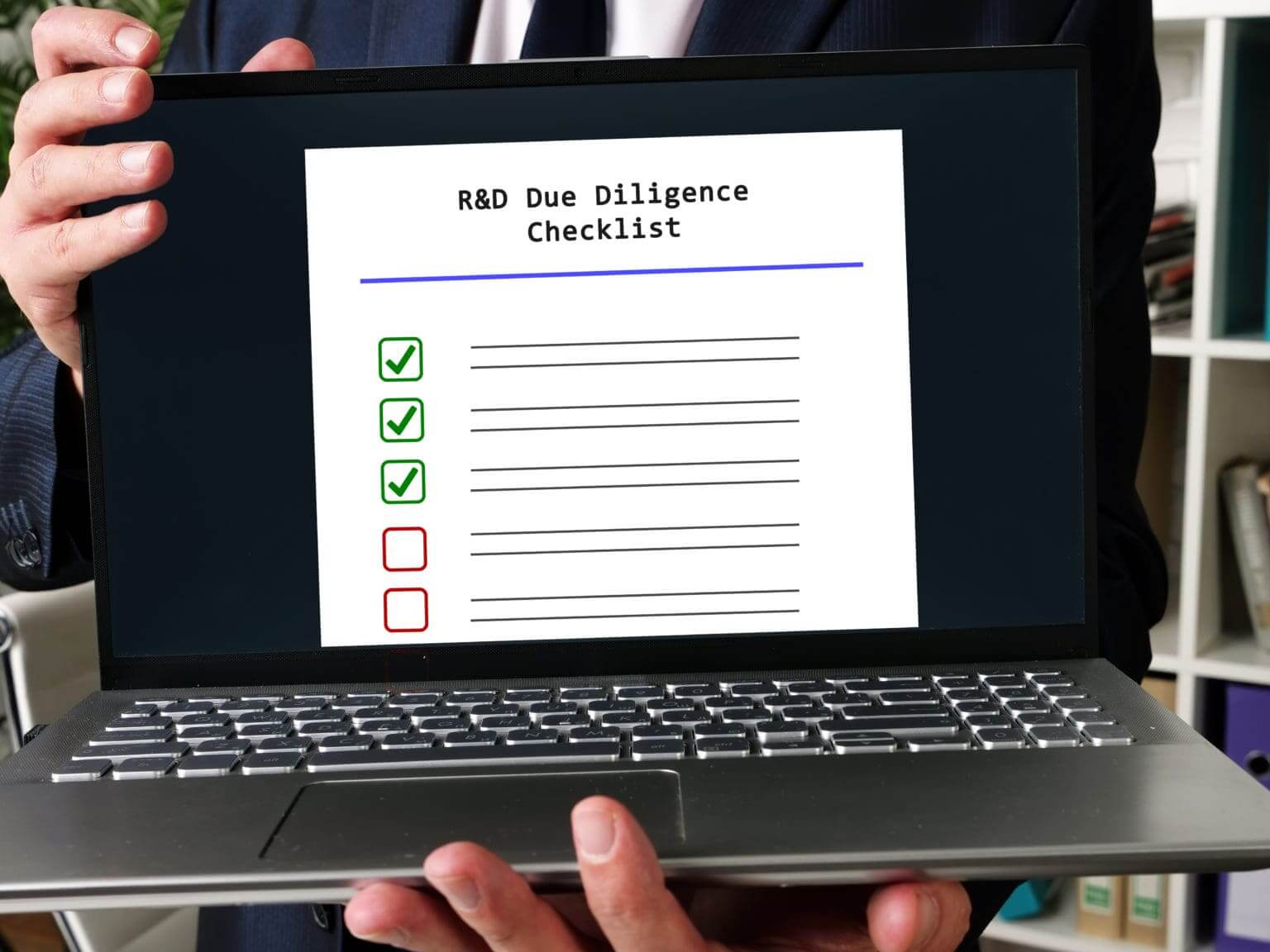 The picture of a man holding a laptop