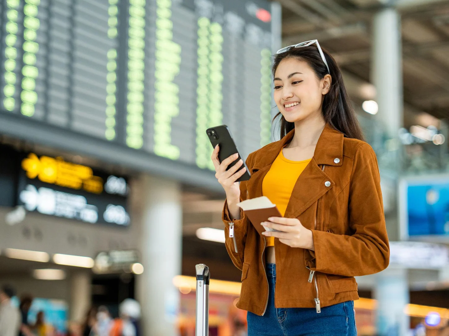 Traveler using a smartphone and boarding pass at an airport