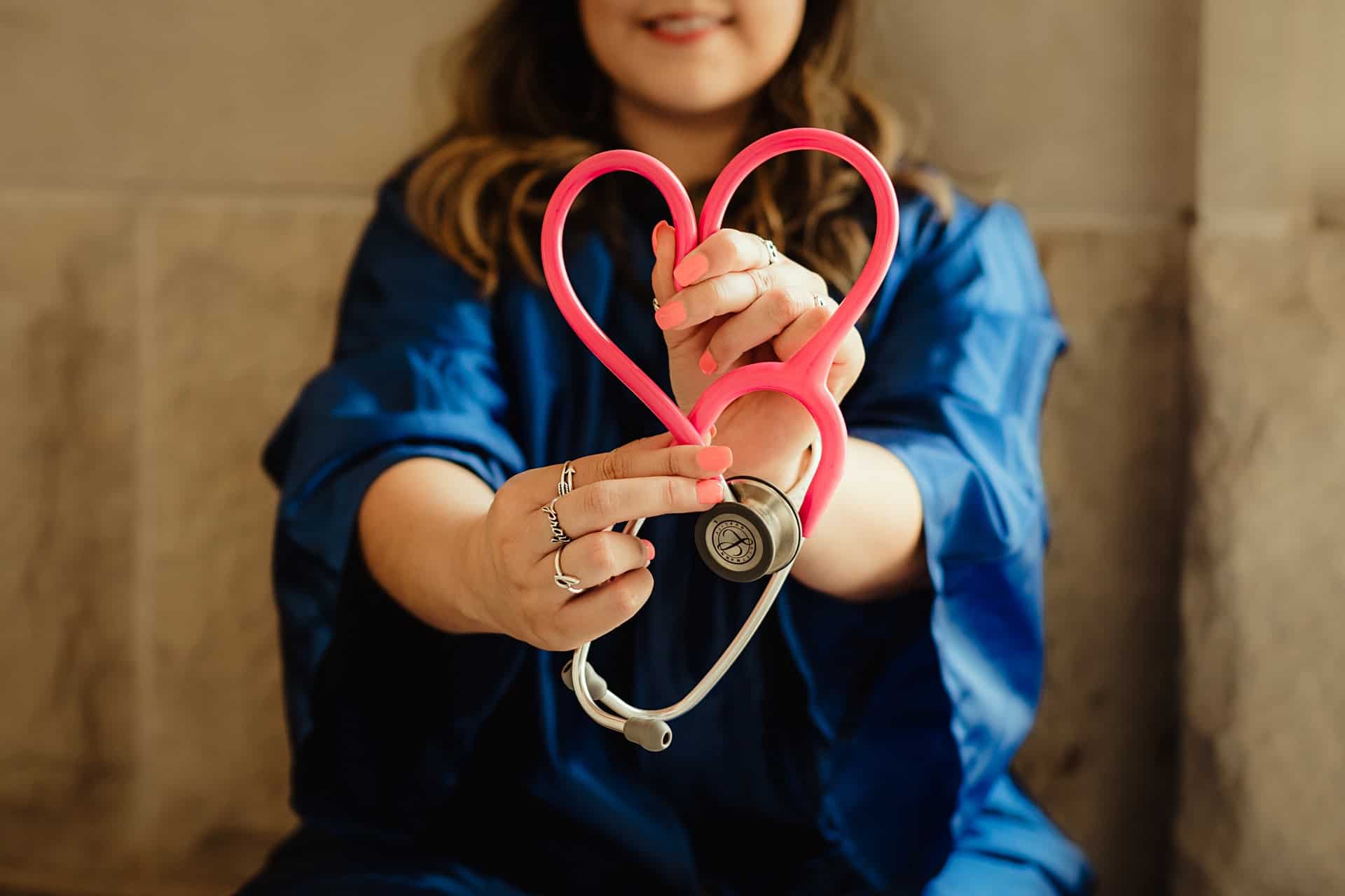 A nurse twisting a stethoscope into a heart.