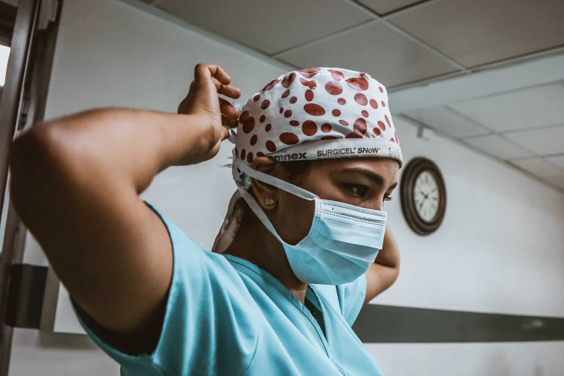 A nurse adjusting her mask.