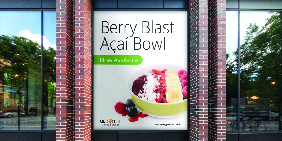 Window advertisement showing a Berry Blast Açaí Bowl with banana, raspberries, blueberries, and coconut flakes, labeled 'Now Available' by Get Fit Juices & Shakes.