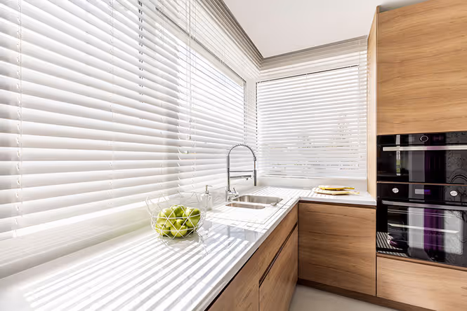 Kitchen with white blinds installed in the window sink 