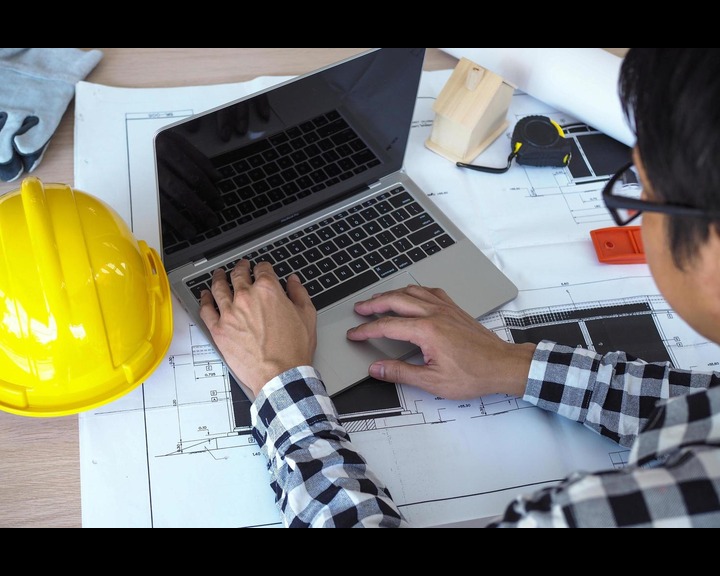 Engineer reviewing structural calculations and design drawings.