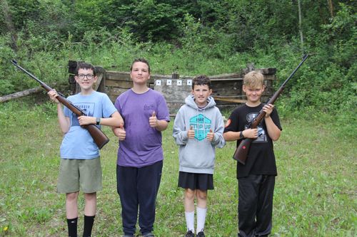 Two campers show of their paintings.