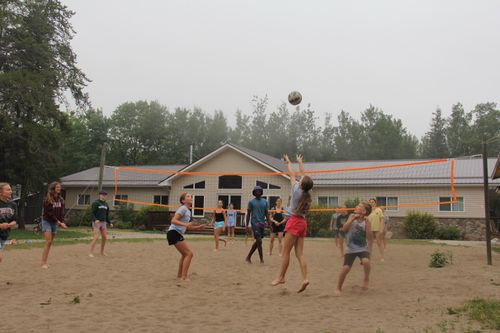 Campers play beach volleyball.