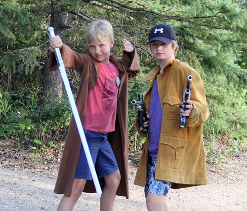 Campers and a counsellor wearing costumes put on a play.