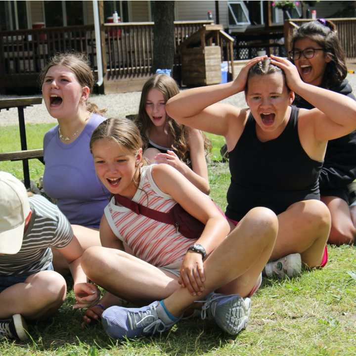 Campers and a counsellor wearing costumes put on a play.