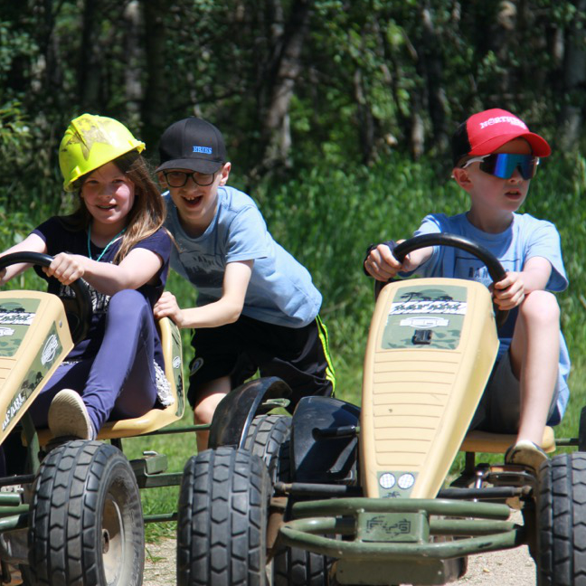 Boys steer pedal carts.
