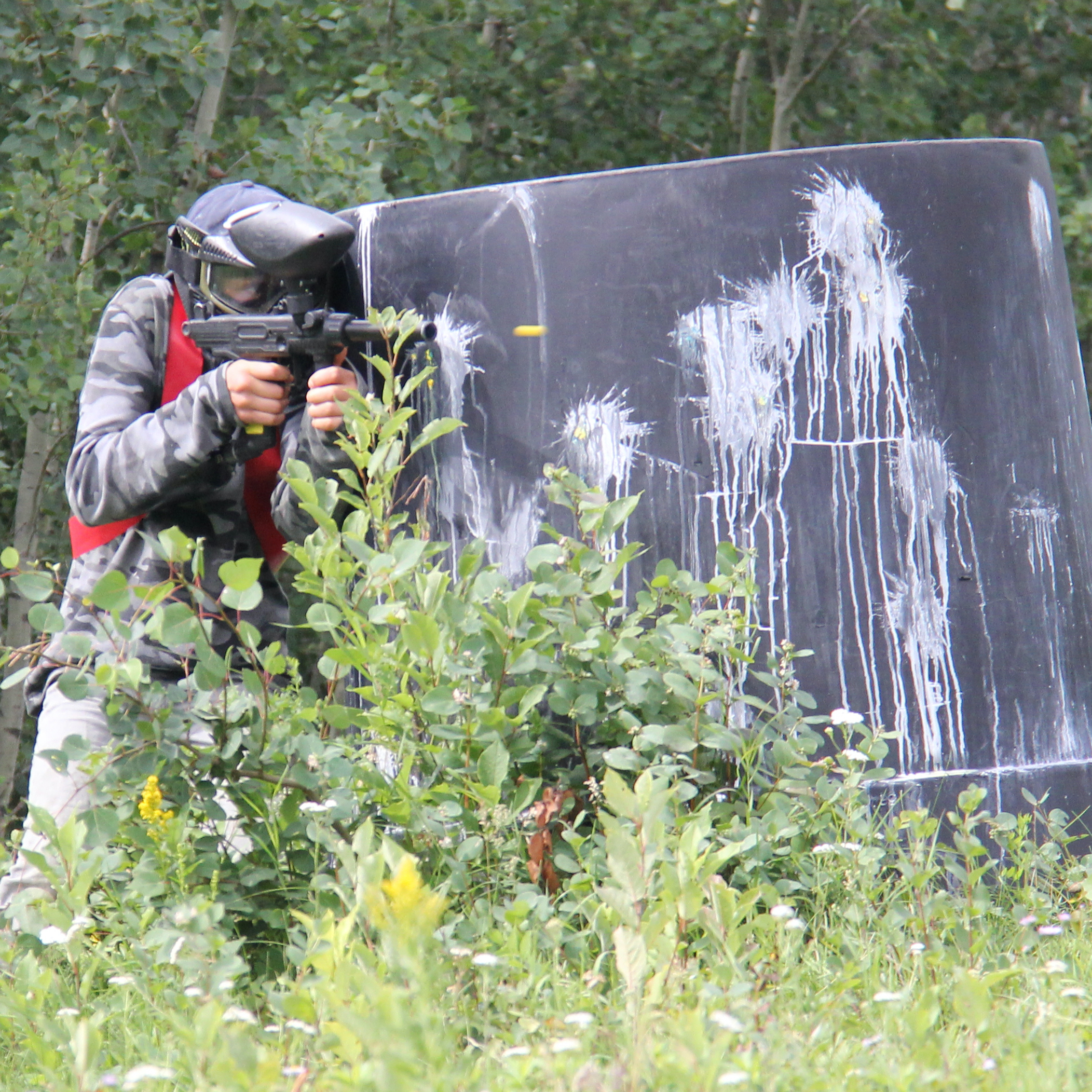Kids with protective masks on get ready to play paintball.