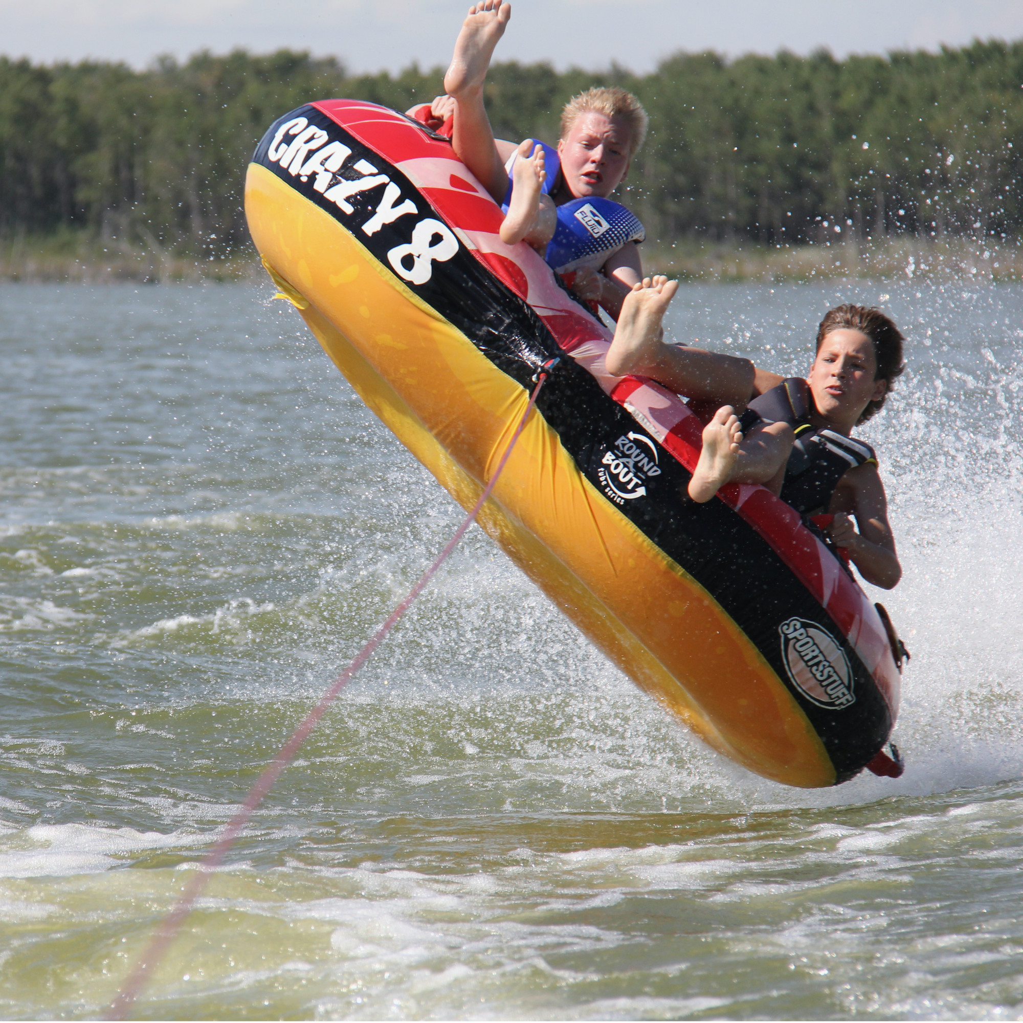 Kids on two tubes on a lake.