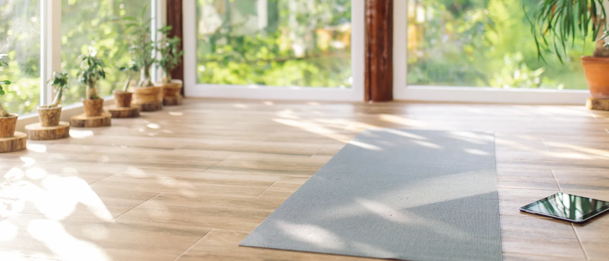 A yoga mat on a tile floor in a sunny indoor patio