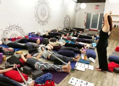 teacher teaching a yin yoga pose to group of students