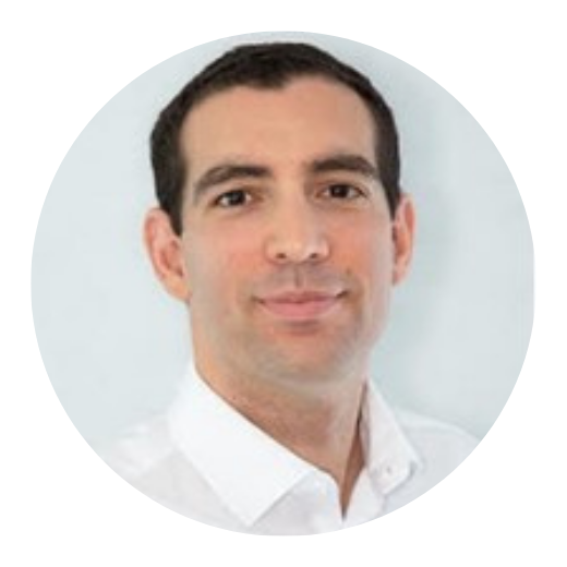 Man with short dark hair wearing a white shirt, looking at the camera with a slight smile.