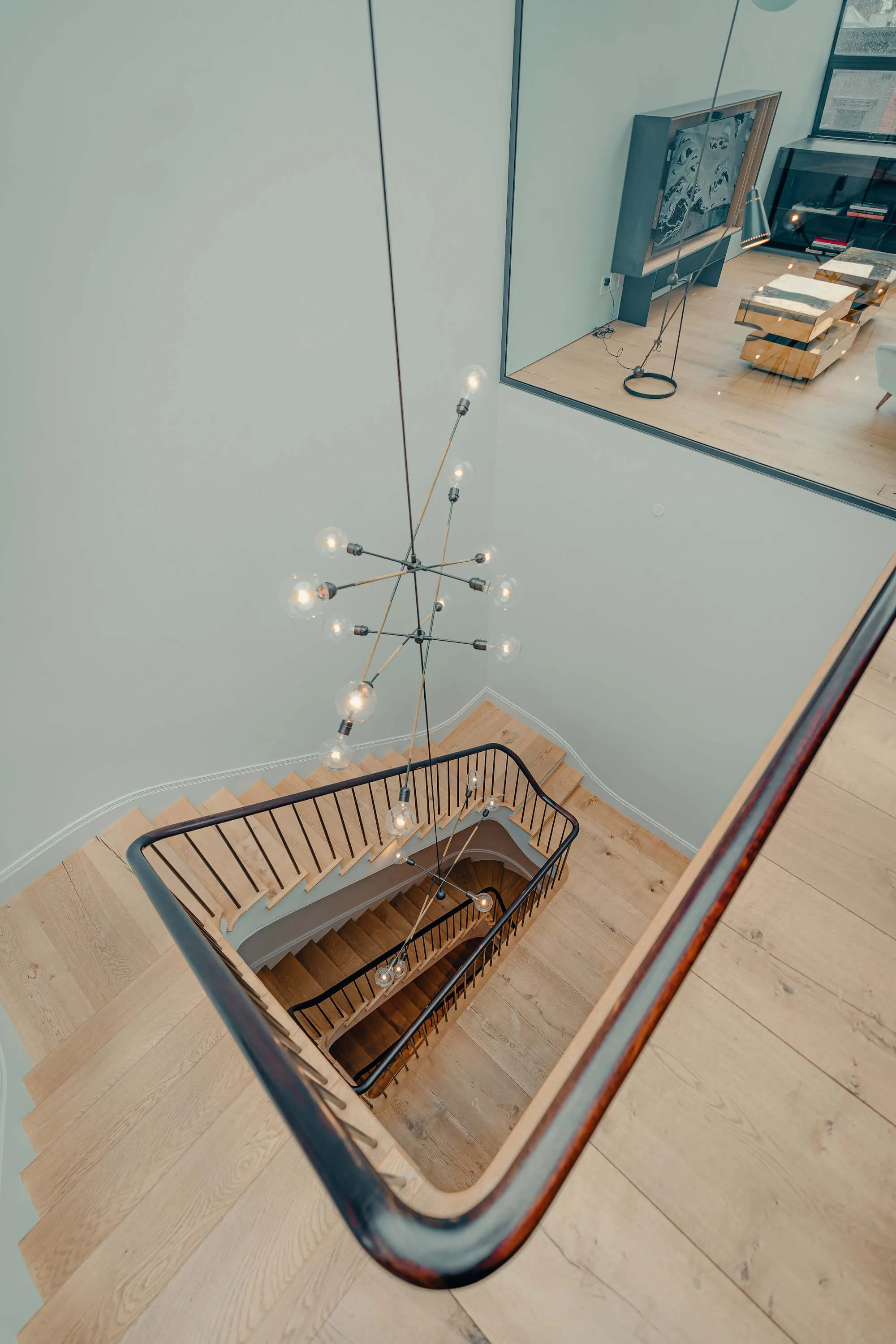 Spiral staircase lit by a modern pendant, residential lighting design by PSE Audio Visual