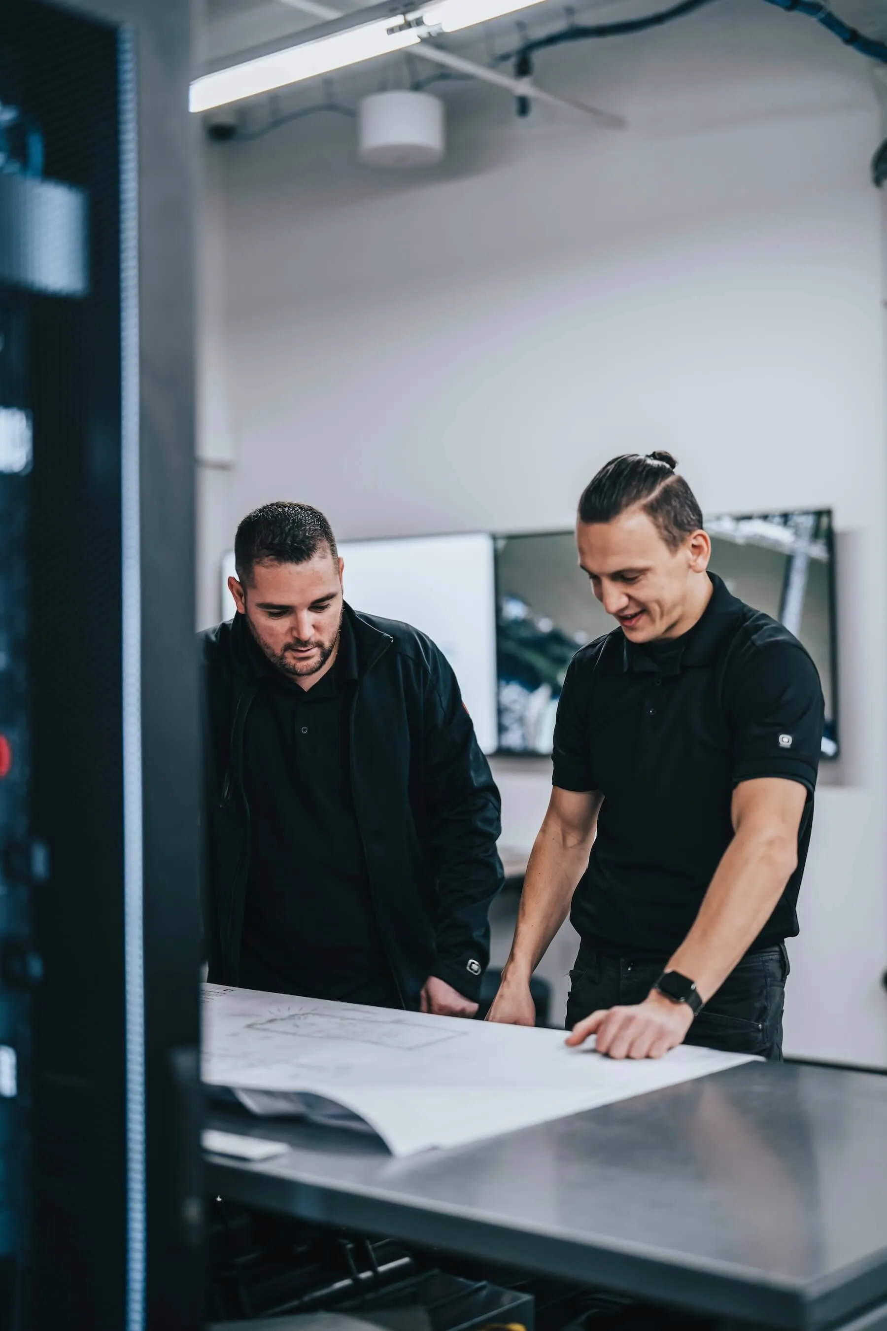 Two PSE Audio Visual team members reviewing commercial AV design plans