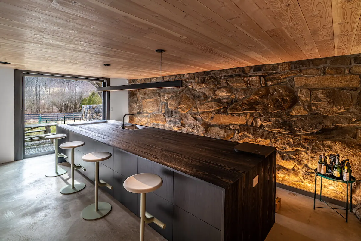 Bar with a lit stone wall at the Westchester Residence, part of a PSE lighting control project
