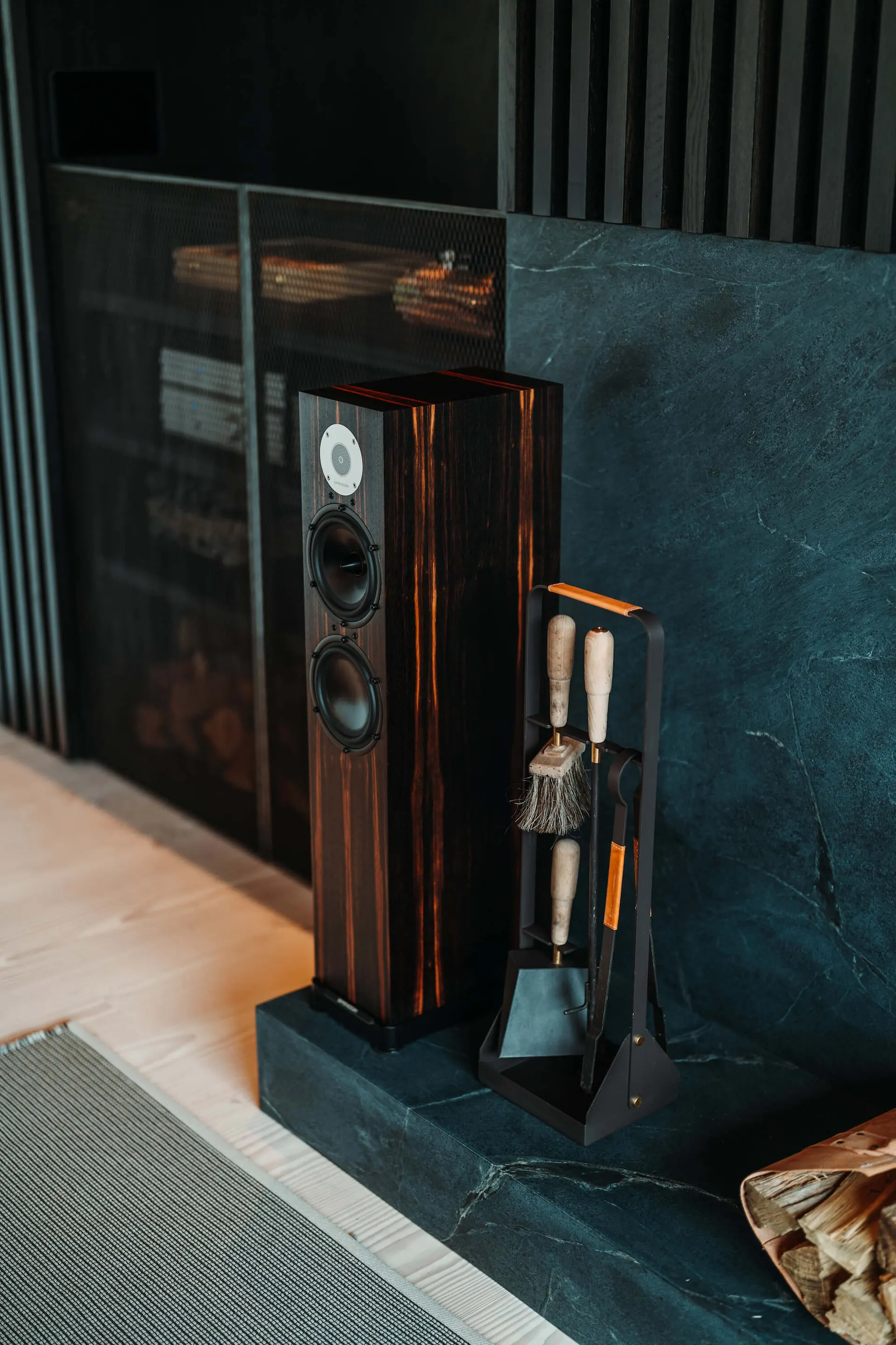 Tower speaker beside a fireplace at the Westchester Residence, a smart home project by PSE